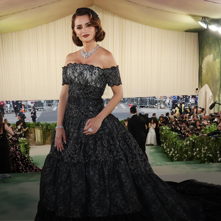 Penélope Cruz pairs classic Chanel gown with cozy layer, exudes elegance.